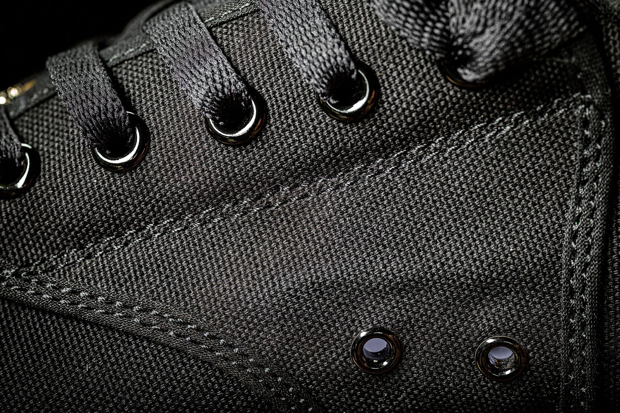 Close-up detail of black knit fabric and laces showing premium texture